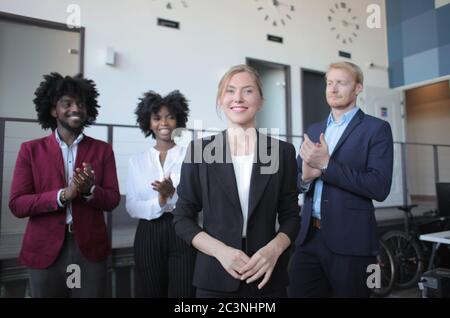 Leader di squadra femminile di successo in un abito formale che presenta il nuovo progetto per partner multietnici Foto Stock