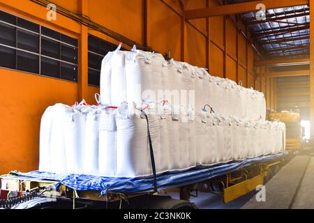 Carico camion jumbo sacchi di tapioca al magazzino dock per l'esportazione attraverso il porto. Logistica dei prodotti agroindustriali e catena di fornitura. Foto Stock