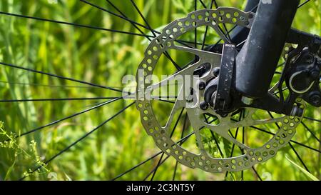 Disco del freno per bicicletta su fondo verde erba. Foto Stock