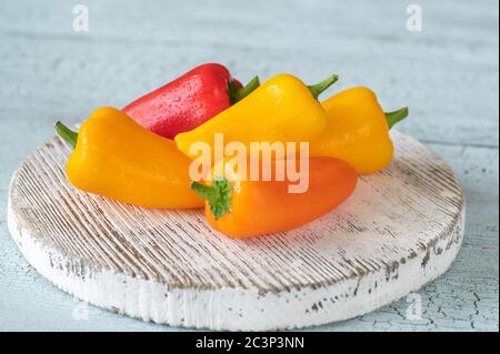 Peperoni dolci freschi su tavola di legno Foto Stock