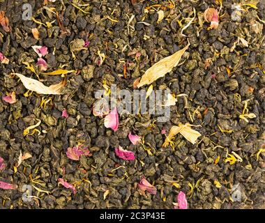 Legare il tè Guan Yin con i petali di lilla, ibisco e girasole. Tè biologico di fondo. Vista dall'alto. Primo piano. Foto Stock