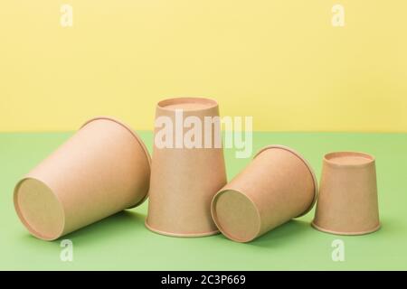 Tazze di carta su sfondo verde e giallo. Foto Stock