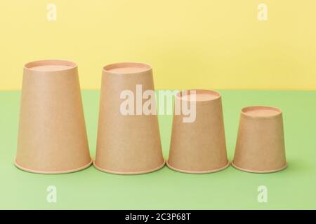 Tazze di carta su sfondo giallo e verde. Foto Stock