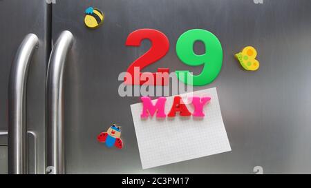 Data di calendario maggio 29 fatta con lettere magnetiche di plastica che tengono una nota di carta grafica sul frigorifero della porta Foto Stock