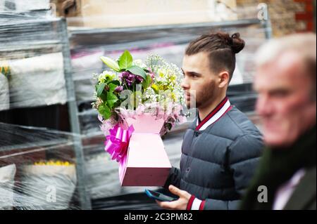 LONDRA - 31 MARZO 2019: Un giovane porta un bouquet di fiori primaverili per la festa della mamma sulla strada al mercato dei fiori di Columbia Road. Foto Stock