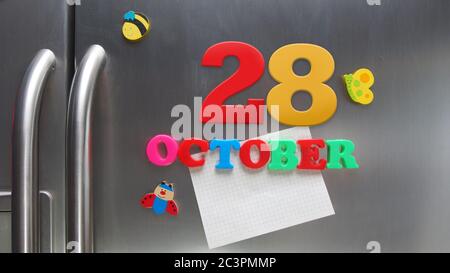 Ottobre 28 data di calendario fatta con lettere magnetiche di plastica che tengono una nota di carta grafica sul frigorifero della porta Foto Stock