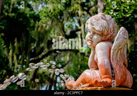 Un cherubino si trova in cima a una fontana nel giardino del Parco Archeologico della Fontana della Gioventù di Ponce de Leon a St. Augustine, Florida. Foto Stock