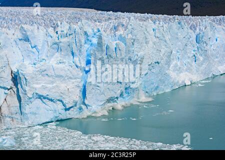 Ghiaccio che comincia a cadere da un ghiacciaio Perito Moreno nel Parco Nazionale Los Glaciares in Argentina Foto Stock