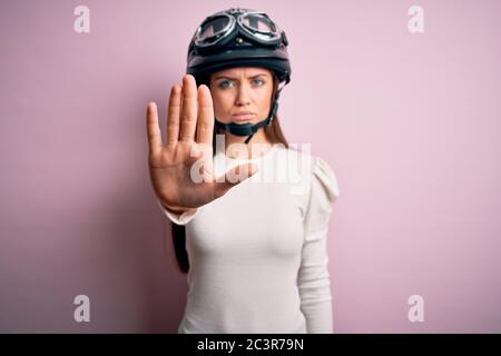 Bella motociclista donna con capelli ricci che indossa casco moto