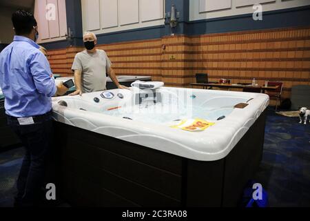 New Orleans, Stati Uniti. 21 Giugno 2020. Le persone che indossano maschere facciali sono viste al National Hot Tub Expo di New Orleans, Louisiana, Stati Uniti, il 21 giugno 2020. Diversi stati Uniti hanno visto un aumento in casi COVID-19 come le aziende continuano a riprendere le operazioni in tutta la nazione, gettando un'ombra sul percorso attuale per riaprire. A partire da domenica pomeriggio, negli Stati Uniti sono stati segnalati più di 2.2 milioni di casi confermati di COVID-19, con oltre 119,800 decessi, secondo uno strumento di monitoraggio dei dati sviluppato dalla Johns Hopkins University. Credit: LAN Wei/Xinhua/Alamy Live News Foto Stock