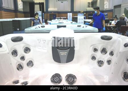 New Orleans, Stati Uniti. 21 Giugno 2020. Le persone che indossano maschere facciali sono viste al National Hot Tub Expo di New Orleans, Louisiana, Stati Uniti, il 21 giugno 2020. Diversi stati Uniti hanno visto un aumento in casi COVID-19 come le aziende continuano a riprendere le operazioni in tutta la nazione, gettando un'ombra sul percorso attuale per riaprire. A partire da domenica pomeriggio, negli Stati Uniti sono stati segnalati più di 2.2 milioni di casi confermati di COVID-19, con oltre 119,800 decessi, secondo uno strumento di monitoraggio dei dati sviluppato dalla Johns Hopkins University. Credit: LAN Wei/Xinhua/Alamy Live News Foto Stock