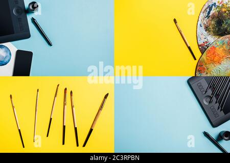Collage di tavolette grafiche, disegni acquerelli e pennelli su superfici blu e gialle Foto Stock