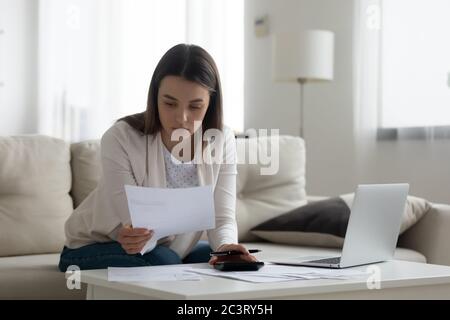 Il contabile che lavora con le fatture calcola le spese che lavorano a casa Foto Stock