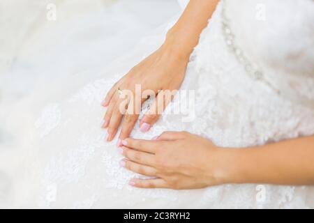 Anello di aggancio sul dito della sposa. Giorno di nozze. Bell'anello di fidanzamento sulla mano di una donna . Foto Stock