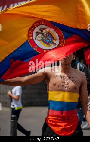 Lo studente ondeggia bandiera mentre ha scritto nel petto la bandiera colombiana dipinta e la frase 'se parliamo ci uccideranno, e se non lo faranno anche' Foto Stock