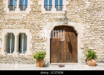 Antico castello di campagna, casa con muro di pietra, porta in legno e finestre. Esterno di un edificio storico Foto Stock