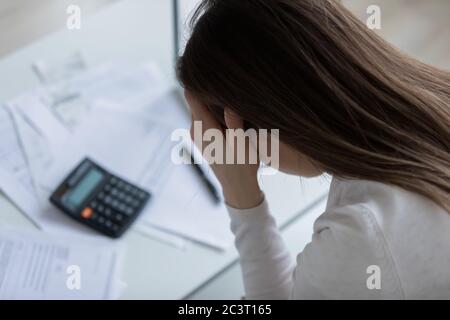 La donna si sente disperata dopo aver calcolato le spese avendo problemi finanziari Foto Stock