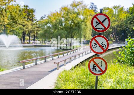 Non è possibile attraversare la strada in bicicletta, non pescare, né saltare in acqua, pericolo rosso e segnali di avvertimento Foto Stock