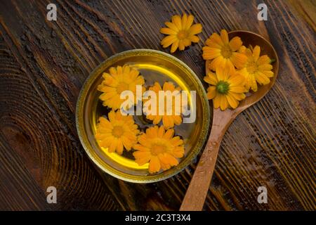Concetto DI SPA. Calendula officinalis su fondo di legno con gocce d'acqua Foto Stock