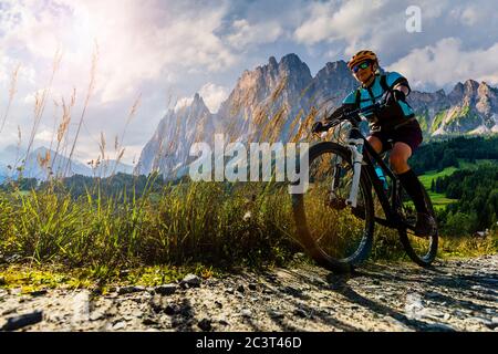 Avventura in bicicletta all'aperto nelle Dolomiti. Donna in bicicletta nel paesaggio delle Dolomiti. Donna ciclismo pista di enduro MTB. Attività sportive all'aperto. Foto Stock