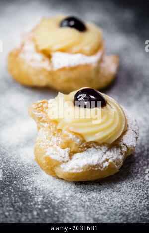 Zeppole fatto in casa di San Giuseppe su tavola rustica Foto Stock