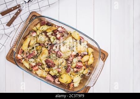 Polpo al forno con patate e olive su tavola bianca, vista dall'alto Foto Stock