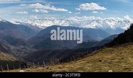 Paesaggio di una valle di alta montagna con le montagne innevate sullo sfondo. Immagine orizzontale Foto Stock