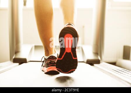 Ragazza Fitness in esecuzione sul tapis roulant. Donna con gambe muscolare in palestra Foto Stock