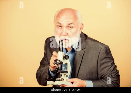 Lavori di dottorato e di post-dottorato dell'occupazione. Biologia docente esperto. Professore docente universitario. Scienziato di microbiologia. Biologia molecolare dei progetti di dottorato. Uomo maturo abito formale con il microscopio. Foto Stock