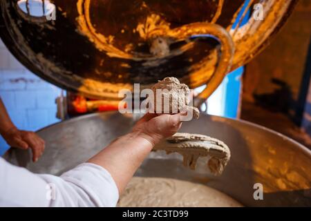 Lifestyle reportage fotografia di una torta e pasticceria all'ingrosso fabbrica di panetteria lavoratore che fa pasta di pasticceria in miscelatore gigante Foto Stock