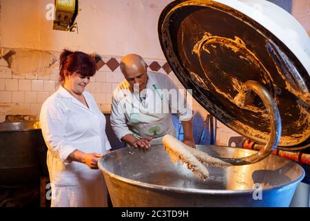 Lifestyle reportage fotografia di una torta e pasticceria all'ingrosso fabbrica di panetteria lavoratore che fa pasta di pasticceria in miscelatore gigante Foto Stock