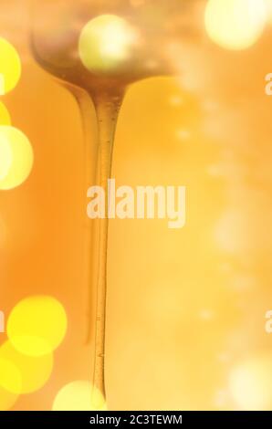 Schizzi di miele dolce biologico. Miele che si immerge dal cucchiaio di miele di legno Foto Stock