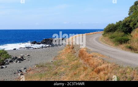 La strada asfaltata che corre lungo la costa selvaggia di Cuba orientale Foto Stock