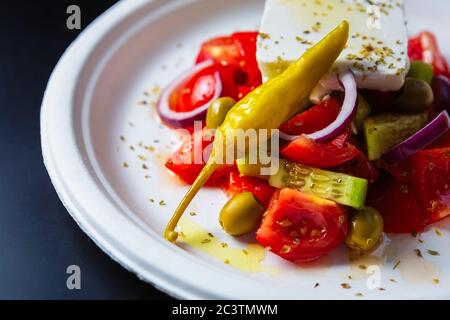 Deliziosa insalata greca cucinata con formaggio feta bianco con basso contenuto di grassi, peperoni caldi e dolci, cetrioli a fette con olio d'oliva per una sana colazione a buffet in f Foto Stock