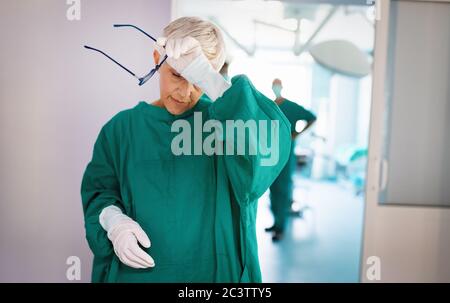 Chirurgo senior dopo che ha fallito un'operazione. Stanco, overlavored, persone, concetto di ospedale. Foto Stock