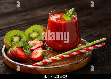 Frullato di fragola e kiwi, su sfondo scuro. Foto Stock