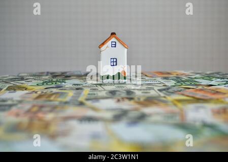 modello di denaro e casa sul tavolo Foto Stock