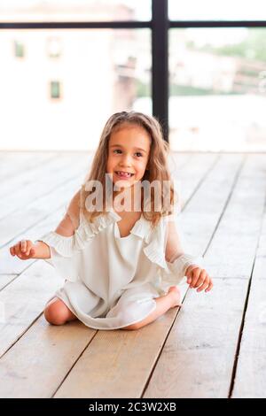 Affascinante bambina con paralisi cerebrale infantile che cerca di sedersi e ballare. Concetto di malattia della paralisi cerebrale infantile Foto Stock