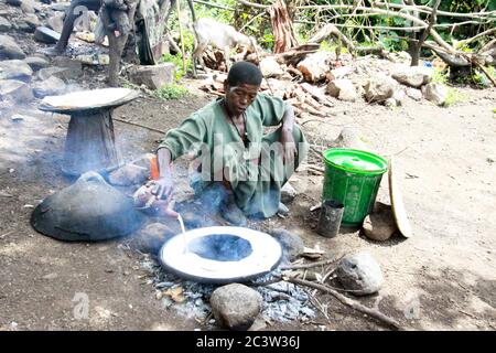 Africa, Etiopia, Lalibela, Donna cuoce injera (injera è un pane piatto lievitato con una consistenza unica e leggermente spugnosa. Tradizionalmente fatto fuori o Foto Stock