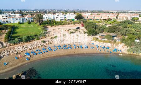 Veduta aerea dall'alto della spiaggia di Sirena a Protaras, Paralimni, Famagosta, Cipro. La famosa attrazione turistica della baia di Sirina con lettini, sabbia dorata, Foto Stock