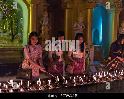 dh Shwedagon Pagoda tempio YANGON MYANMAR Buddhista templi persone candela Illuminazione candele cerimonia rituali tradizionali donne zedi daw Great Dagon Foto Stock