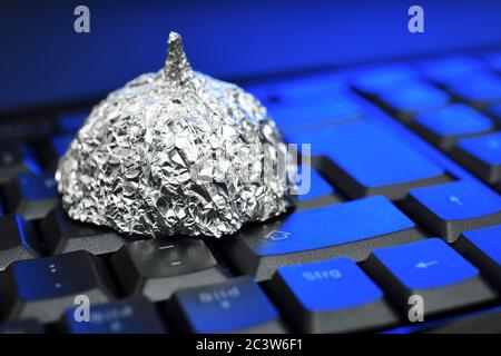 Cappello in lamina di stagno sulla tastiera del computer, foto di simbolo per teorie di cospirazione su Internet, Aluhut auf Computertastatur, Symbolfoto für Verschwörungstheo Foto Stock