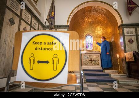 Don Peter Sutton si prepara a lasciare spazio alla preghiera privata nella cappella commemorativa della chiesa parrocchiale di St Cuthbert a Edimburgo, seguendo il passaggio della Scozia alla seconda fase del suo piano in quattro fasi per facilitare l'uscita dal blocco. Presso la chiesa saranno messe in atto misure di allontanamento sociale, comprese le stazioni di igiene delle mani e un sistema unidirezionale. Foto Stock