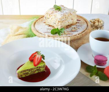 composizione di dessert su sfondo chiaro. Torte con frutta e una tazza di tè Foto Stock