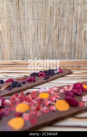 diversi tipi di cioccolato con frutta secca su tavola di legno Foto Stock