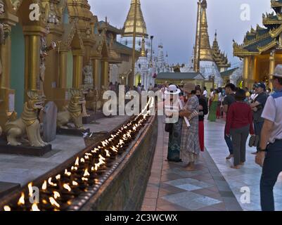 dh Shwedagon Pagoda tempio YANGON MYANMAR ASIA templi buddisti turisti candela di illuminazione persone candele rituali turistici cerimonia di luce tradizionale Foto Stock