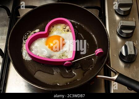 Uovo fritto cotto a forma di cuore Foto Stock