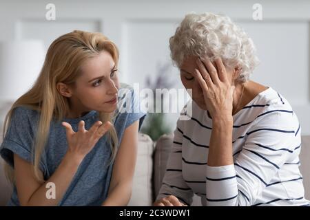 La figlia di Grunnup dimostra il suo diritto aggressivamente discutere con la madre anziana Foto Stock