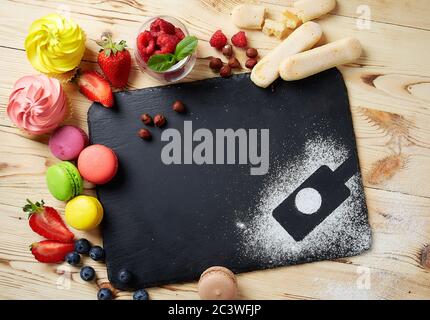 composizione di dessert su fondo di pietra nera. Torte con frutta e una tazza di tè. Con spazio per la copia. Spazio per il logo Foto Stock