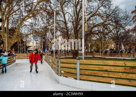 Pattinaggio sul ghiaccio natalizio nel centro di Vienna. Pista di pattinaggio a Rathauspark. Sentieri di ghiaccio tortuosi attraverso il romantico City Hall Park, Vienna, Austria. Foto Stock